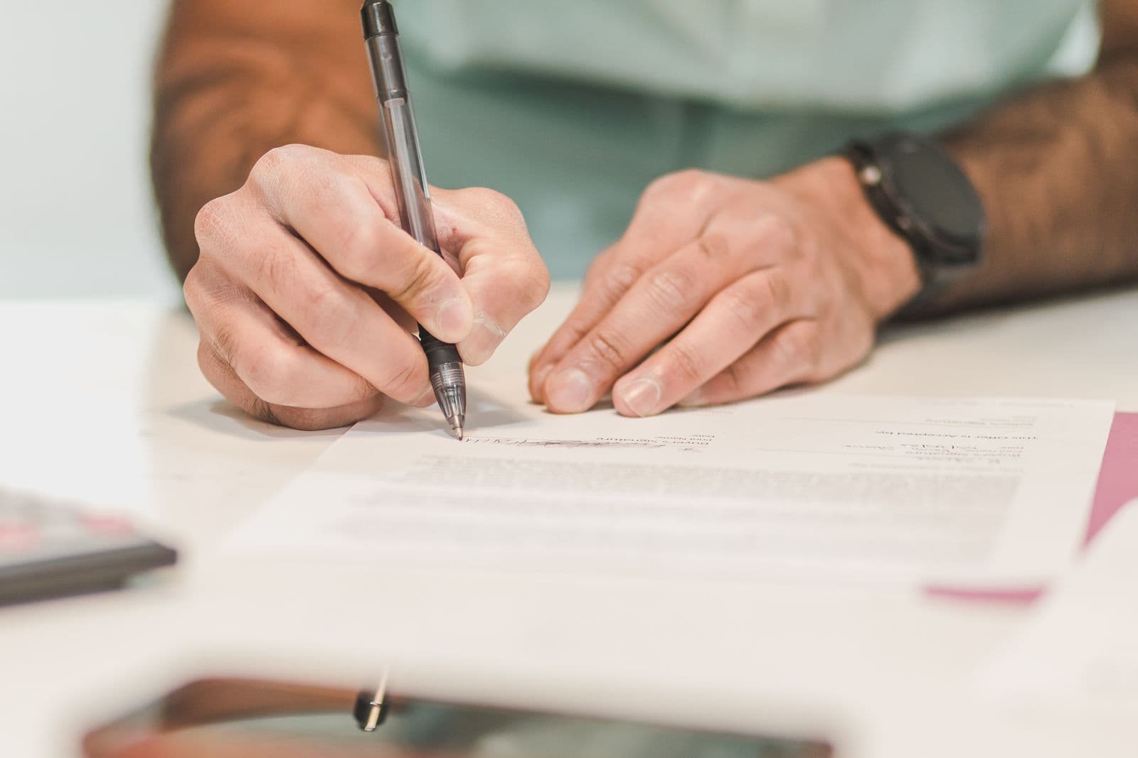 A person signing a formal document with a pen
