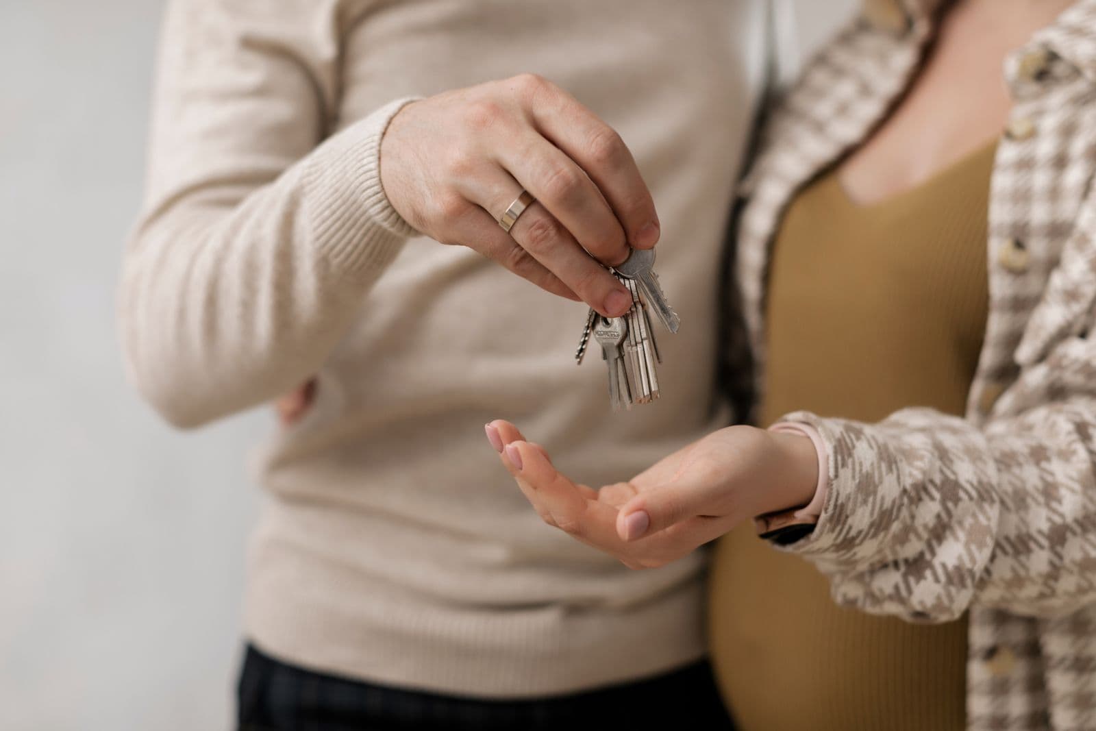 One person handing a set of house keys to another